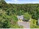 Stunning aerial view of a white home nestled among lush green trees on a beautiful, sunny day at 166 Greenmont Ln, Cary, NC 27511