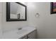 Charming half-bathroom boasts a modern mirror, a framed artwork, and a vanity at 166 Greenmont Ln, Cary, NC 27511