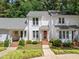 Charming townhome featuring a red door, brick path, and manicured landscaping at 166 Greenmont Ln, Cary, NC 27511