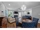Open-concept living room with elegant chandelier, fireplace, and wood flooring at 166 Greenmont Ln, Cary, NC 27511