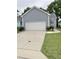 Garage of a blue home with an ample driveway and landscaping at 1944 Castle Pines Dr, Raleigh, NC 27604
