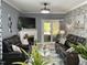 Inviting living room with comfortable black leather sofas, fireplace, and patio access at 1944 Castle Pines Dr, Raleigh, NC 27604