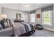 A nicely styled bedroom with good natural light features two large windows and a casual bean bag chair at 212 Augusta Pond Way # 128, Raleigh, NC 27603