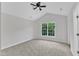 Spacious bedroom with vaulted ceiling, neutral carpet, and large window overlooking greenery at 2204 Bellaire Ave, Raleigh, NC 27608
