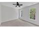 Bright bedroom with ceiling fan, carpeted floor, and windows for natural light at 2204 Bellaire Ave, Raleigh, NC 27608