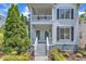 Beautifully landscaped two-story home featuring a double porch with white trim and dark shutters at 2204 Bellaire Ave, Raleigh, NC 27608