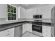 Updated kitchen boasts granite countertops, stainless steel appliances, and white marble floors at 2204 Bellaire Ave, Raleigh, NC 27608