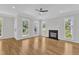 Open living room featuring hardwood floors, a fireplace, and large windows that bring in natural light at 2204 Bellaire Ave, Raleigh, NC 27608