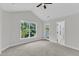 Bright main bedroom features vaulted ceiling, neutral carpet, and large window with backyard view at 2204 Bellaire Ave, Raleigh, NC 27608