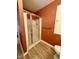 Bathroom featuring a tiled shower with glass door and wood laminate flooring at 225 Meadow Dr, Henderson, NC 27537