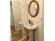 Compact half-bathroom featuring a pedestal sink, a large mirror, and wood-look flooring at 225 Meadow Dr, Henderson, NC 27537