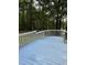Light blue deck with white railings overlooking the wooded area in this charming outdoor space at 225 Meadow Dr, Henderson, NC 27537