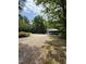 Wide gravel driveway and lush surroundings showcasing a home with a carport at 225 Meadow Dr, Henderson, NC 27537