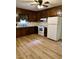 A traditional kitchen featuring wood cabinets, modern white appliances and updated flooring at 225 Meadow Dr, Henderson, NC 27537