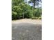 Gravel parking area is surrounded by mature trees at 225 Meadow Dr, Henderson, NC 27537