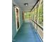 A long, cozy blue porch extends into a peaceful wooded area with a porch swing at 225 Meadow Dr, Henderson, NC 27537