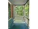 Inviting porch swing overlooks a beautiful wooded property at 225 Meadow Dr, Henderson, NC 27537
