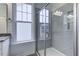 Bathroom with a tiled walk-in shower featuring a glass door and convenient window at 2309 Redbridge Ln, Apex, NC 27502