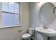 Half bathroom features pedestal sink, toilet, and oval mirror and window at 2309 Redbridge Ln, Apex, NC 27502