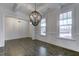 Elegant dining room featuring wainscoting, hardwood floors, a modern chandelier, and plenty of natural light at 2309 Redbridge Ln, Apex, NC 27502