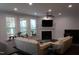 Bright living room with large windows, a fireplace, and comfortable seating, creating a cozy atmosphere at 2309 Redbridge Ln, Apex, NC 27502