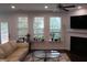 Bright living room with large windows, a fireplace, and comfortable seating, creating a cozy atmosphere at 2309 Redbridge Ln, Apex, NC 27502