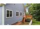 Angled exterior rear view of home featuring backyard deck, white trim, and blue siding at 2313 Filigree Ct, Raleigh, NC 27614