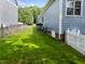 The backyard features lush green grass with white picket fence and a peek at the neighboring yard at 2313 Filigree Ct, Raleigh, NC 27614
