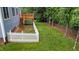 Backyard with a deck, white picket fence and mature tree line at the end of yard at 2313 Filigree Ct, Raleigh, NC 27614