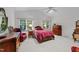 Bright bedroom featuring a vaulted ceiling, two windows, hardwood furniture, and a comfortable plush red chair at 2313 Filigree Ct, Raleigh, NC 27614