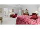 Spacious bedroom featuring a luxurious red bed, elegant furniture, and two entry doors to other rooms at 2313 Filigree Ct, Raleigh, NC 27614