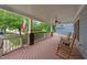 Cozy porch featuring rocking chairs, white railings and columns, and an American flag at 2313 Filigree Ct, Raleigh, NC 27614