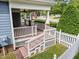 Inviting covered front porch with wood floors, white railings, and a charming rocking chair at 2313 Filigree Ct, Raleigh, NC 27614