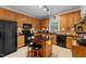 Well-equipped kitchen with black appliances, wooden cabinets, and a functional island at 2313 Filigree Ct, Raleigh, NC 27614
