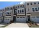 Exterior view of townhomes with two-car garages, varied siding colors, and well-maintained landscaping at 2733 Hunter Woods Dr # 570, Apex, NC 27502