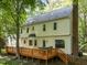 Two-story home featuring a backyard deck and brick chimney set against a backdrop of lush foliage at 2840 Mattlyn Ct, Raleigh, NC 27613