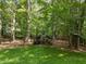 Backyard with mature trees and chicken coop on a lush lawn, providing a country feel at 2840 Mattlyn Ct, Raleigh, NC 27613