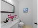 Stylish half bath with modern fixtures, marble countertop, and decorative mirror at 2840 Mattlyn Ct, Raleigh, NC 27613