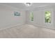Bright bedroom featuring neutral carpet, two large windows, and a decorative world map at 2840 Mattlyn Ct, Raleigh, NC 27613