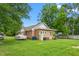 Brick house exterior with covered cars, storage, central air, and a big yard with shady trees at 310 Wood St, Gibsonville, NC 27249
