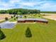 Spacious property aerial view featuring a well-maintained lawn, brick house, and scenic pond area at 3187 Wilsons Mills Rd, Smithfield, NC 27577