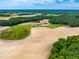 Overhead view of the farm showing the pond surrounded by pastures and tilled land adjacent to a forest at 3187 Wilsons Mills Rd, Smithfield, NC 27577
