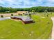 Aerial view of property featuring house, patio, pond, outbuilding, and well-kept lawn at 3187 Wilsons Mills Rd, Smithfield, NC 27577