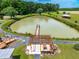 Aerial view of pond with dock, gazebo, patio area, and lush surrounding greenery at 3187 Wilsons Mills Rd, Smithfield, NC 27577