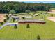Expansive estate featuring a charming brick home, serene pond, and lush landscaping from an elevated perspective at 3187 Wilsons Mills Rd, Smithfield, NC 27577