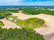 An aerial view of land outlined in yellow, with fields, trees, a house, a pond, and a neighborhood nearby at 3187 Wilsons Mills Rd, Smithfield, NC 27577