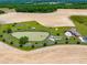 An aerial view showcases the property's pond, home, fields and surrounding landscape at 3187 Wilsons Mills Rd, Smithfield, NC 27577
