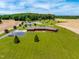Stunning aerial view highlighting the brick home, pond, manicured lawn, and surrounding landscape at 3187 Wilsons Mills Rd, Smithfield, NC 27577