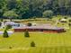Detailed aerial shot showcasing the brick home, lush lawn, and serene pond with a gazebo at 3187 Wilsons Mills Rd, Smithfield, NC 27577