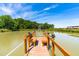 View of a wooden dock on a pond, a peaceful retreat for relaxation or fishing on a sunny day at 3187 Wilsons Mills Rd, Smithfield, NC 27577